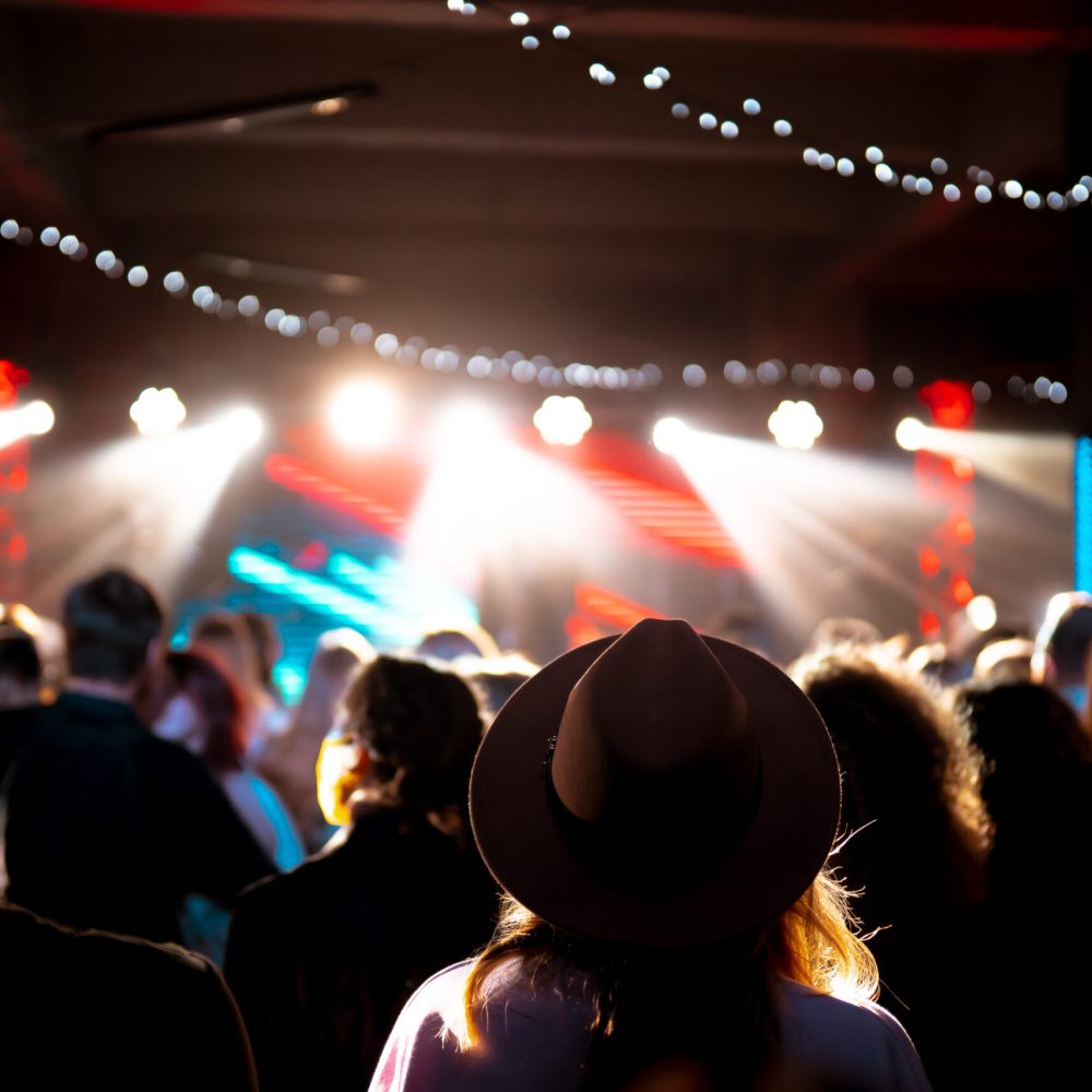 Photo of many people enjoying rock concert, crowd with raised up hands dancing in nightclub